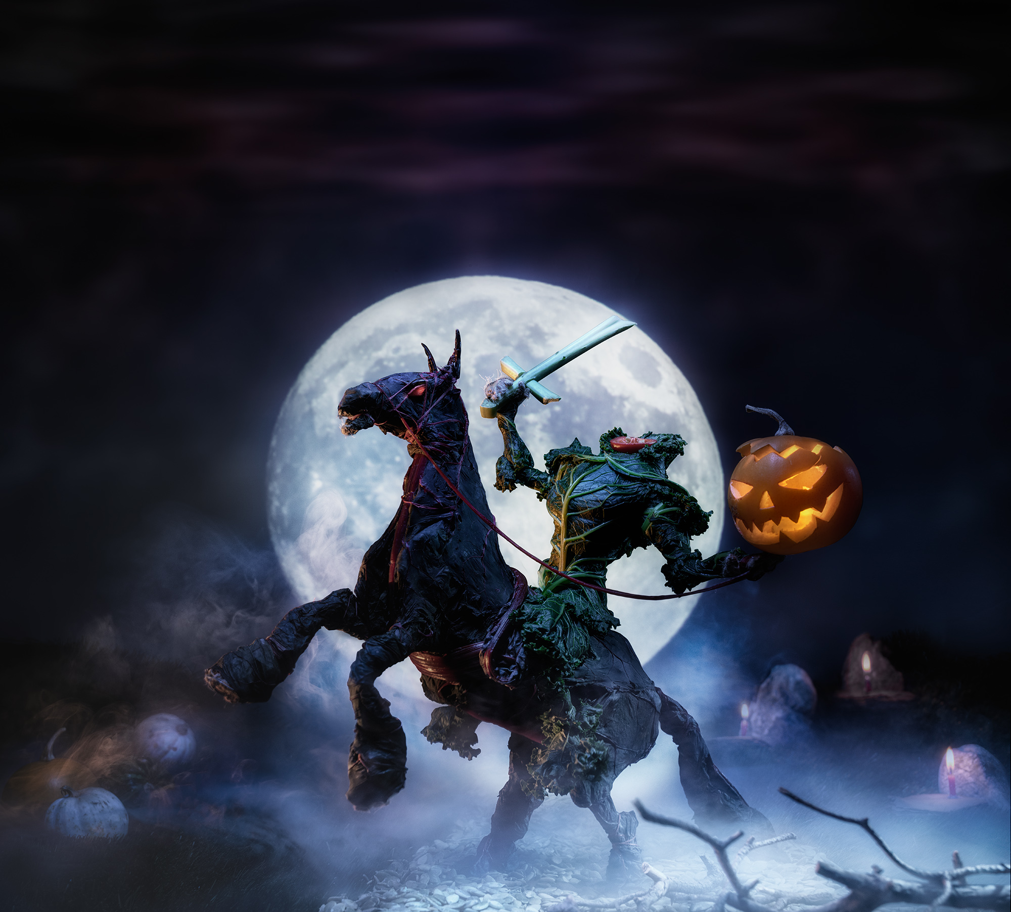 A headless rider made out of kale holding a sword in one hand and a lit pumpkin with carved out face in the other is sitting on a horse which is also made out of kale, the full moon behind them, set on a graveyard in the fog.