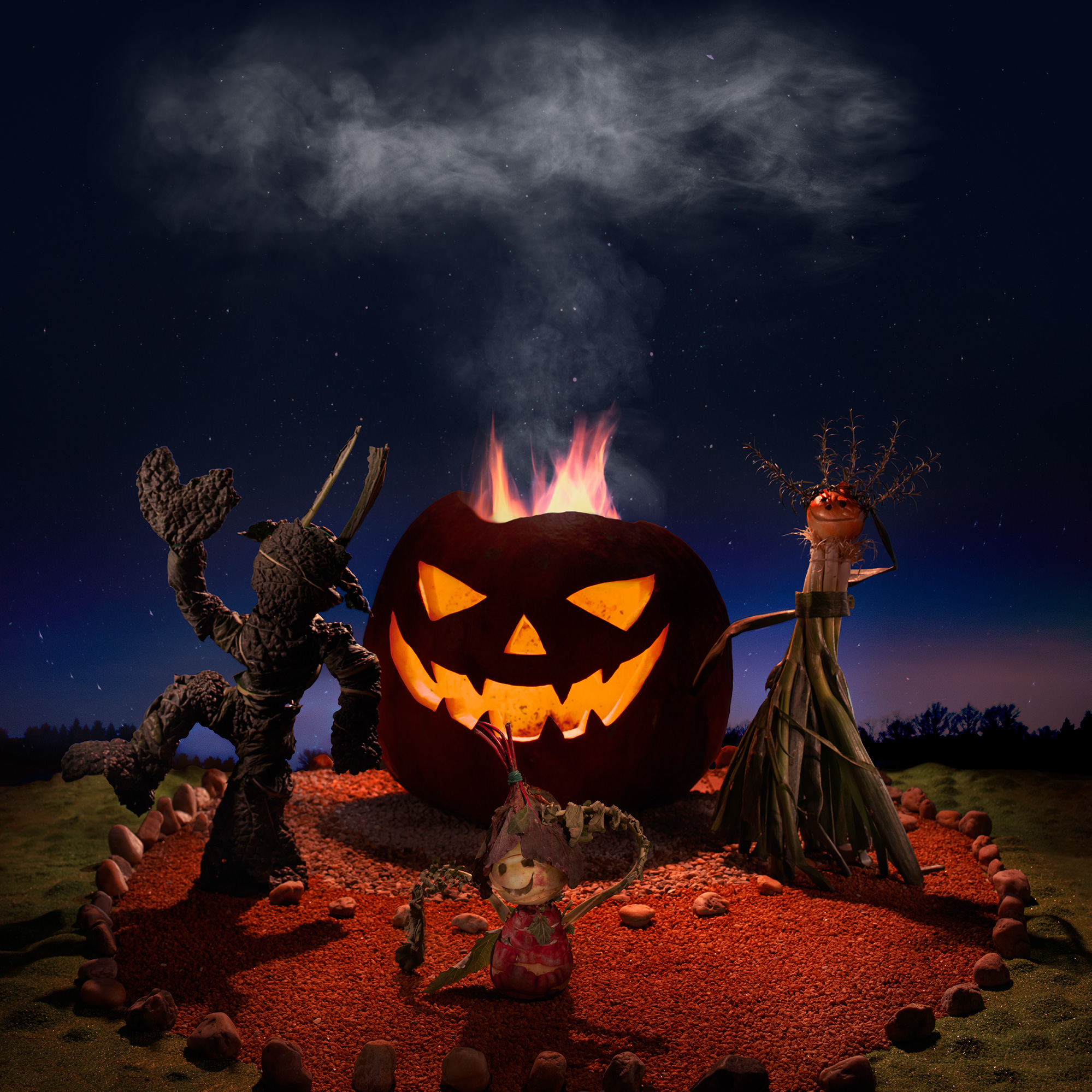 Figures made out of vegetables are dancing around a pumpkin with cut out face and a fire burning within. Kale, turnip and onion.